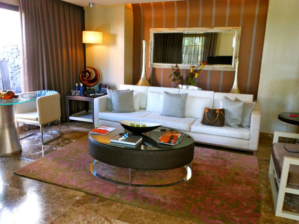 A sunlit modern living room with a white sofa and round coffee table