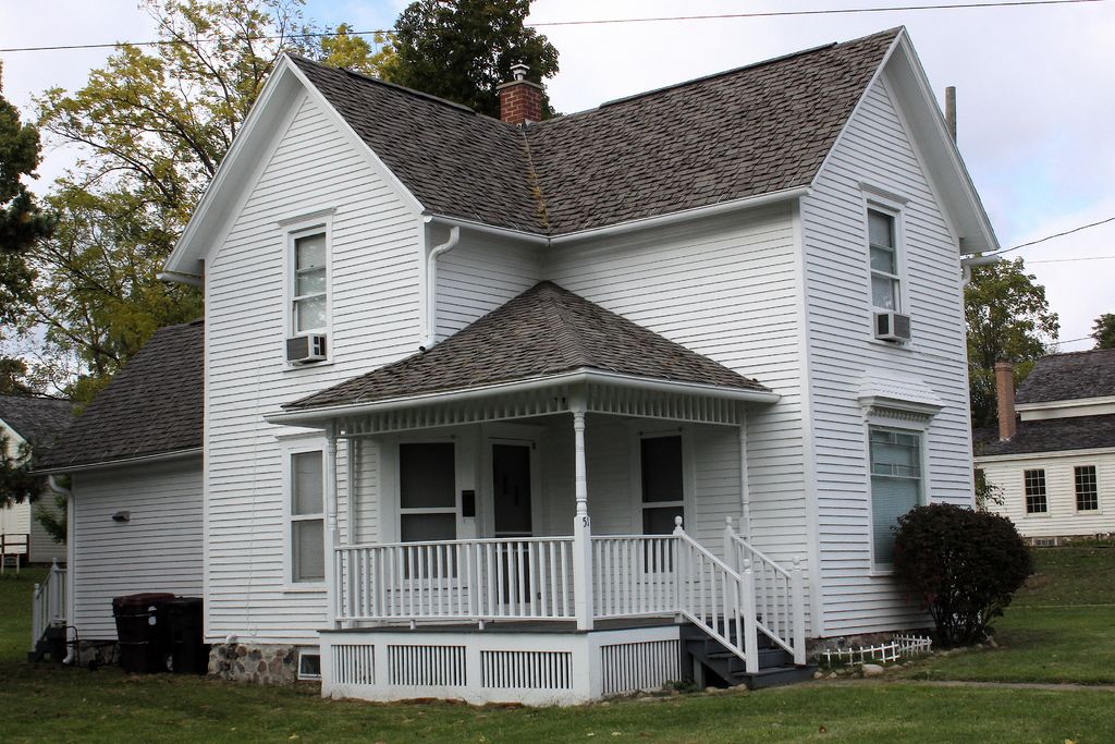 A white clapboard house with a new grey shingle roof