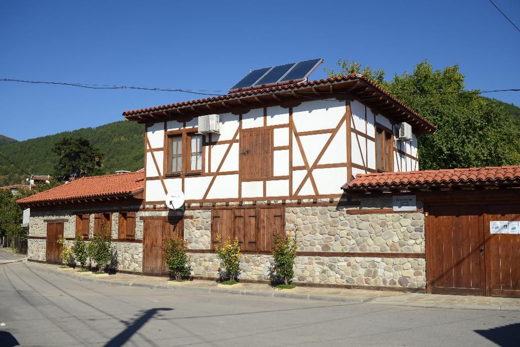 A house with solar panels on its tiled roof under a blue sky